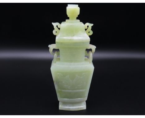 A carved Chinese jade vase with cover, depicting foo dog carving to sides, 178mm tall