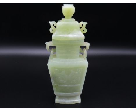 A carved Chinese jade vase with cover, depicting foo dog carving to sides, 178mm tall