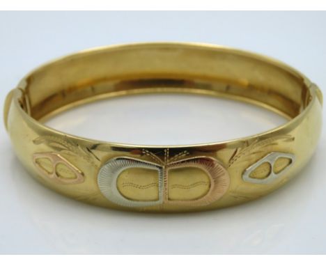 An 18ct three colour gold bangle, 25.1g, with plush box, 61mm internally