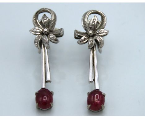 A 14ct white gold pair of screw back drop earrings set with cabochon cut ruby, 8.3g, drop 36mm