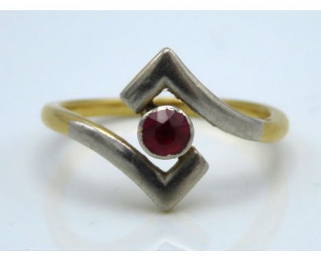A two colour metal ring set with ruby, 4mm diameter, tests electronically as 14ct gold, 3g, size K/L 