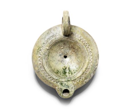  A large Roman lead-glazed pottery oil lamp  Circa 1st Century A.D.With ribbed ring handle and short rounded nozzle, the disc