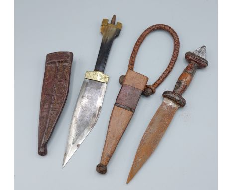 An African Tribal Dagger with Leather Scabbard, together with another similar dagger 