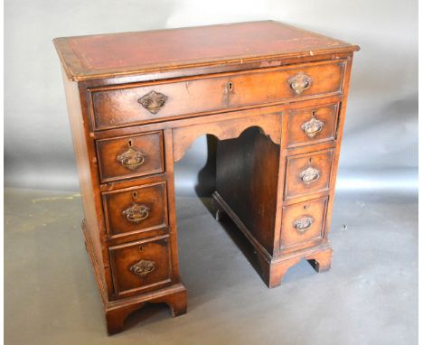 A 20th Century Walnut Queen Anne Style Small Pedestal Desk, the tooled leather inset top with moulded pinched corners above s