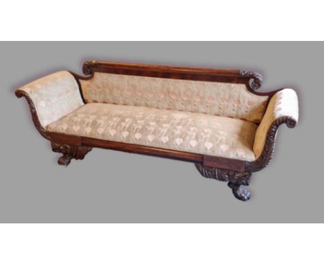 A William IV mahogany sofa, the carved back above a padded back and seat with a carved frieze and raised upon carved paw feet