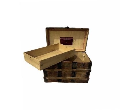 A leather mounted dome top travel trunk, metal and wood banded, document folder affixed to the inside lid, interior fitted wi