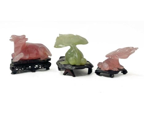 A small collection of jade-type and rose quartz-type carved figurines on stands, fancy goldfish and a resting ox (3)