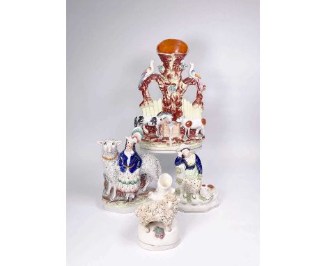 A 19th century Staffordshire figure modelled as a royal child in highland dress and plumed hat leaning against a large sheep 