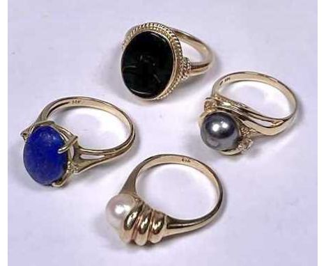 Four gold coloured metal gem-set rings, to include a lapis lazuli and an onyx cabochon single-stone ring, together with two c