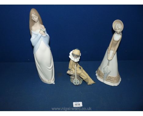 A Nao figure of a pirouette/clown (one finger broken) and figure holding flowers and Spanish lady with parasol.