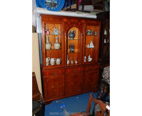 A contemporary Yewwood finished Cabinet on Cupboard, having arched central shelf area flanked by a pair of opposing glazed do