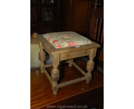 A matt finished Oak framed Stool with drop-in floral upholstered seat and standing on turned legs with perimeter stretchers, 