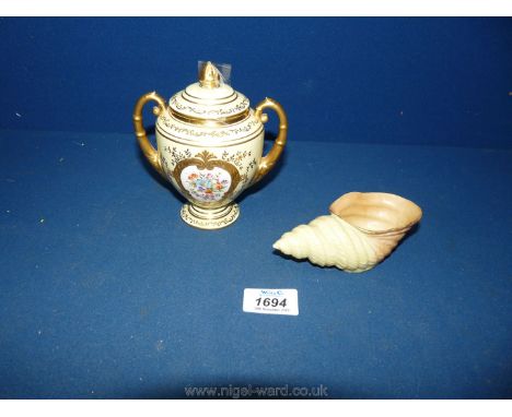 A Coalport lidded gilded Urn with a Royal Worcester conch shell.