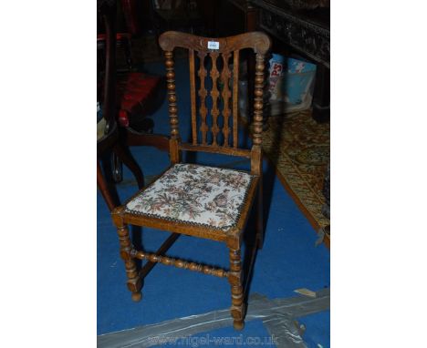 An arts and crafts Mahogany framed side Chair having turned details and fretworked central back splat and floral upholstered 