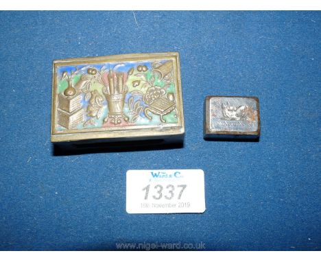 An enamel decorated brass matchbox holder depicting in relief plants in vases, a trivet, etc. in chinosierie style and a poli