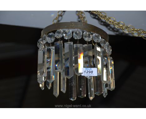 A delightfully plain crystal chandelier having 22 triangular prisms of alternating lengths and with brass finished suspensory