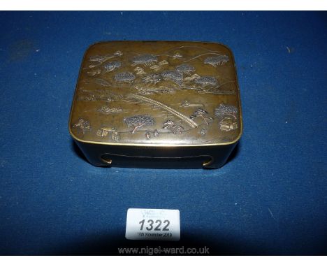 A fine old oriental Brass Trinket Box having a snug fitting lid depicting a scene with polished highlights, a river with fish