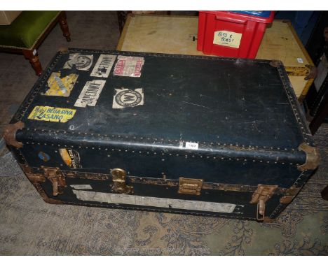 A well travelled Trunk/travelling Wardrobe having metal bound corners, 41'' x 22'' x 18 1/2'' high having labels attached inc