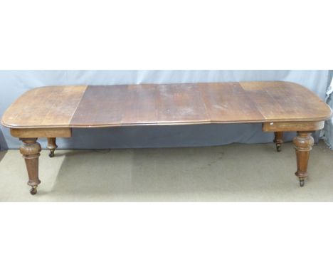 Late 19thC / early 20thC oak wind-out extending dining table with four leaves, moulded edge and carved legs terminating in ce