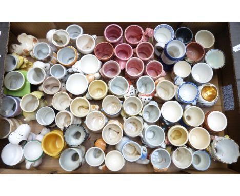 Approximately 60 novelty egg cups including retro, kitsch, Longton Pottery examples, Japanese etc