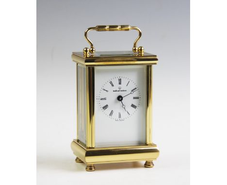A Boodle and Dunthorne carriage timepiece, the lacquered brass case enclosing white enamel, Roman numeral dial, upon four tur