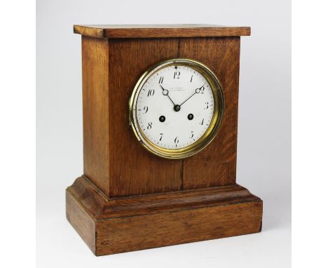 An early 20th century oak cased eight-day mantel clock signed 'Charles Frodsham', the rectangular case enclosing a white enam