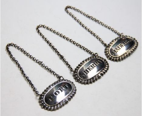 Three 19th century white metal decanter labels, for Port, Sherry and Madieira, each of oval form with gadrooned borders, hang