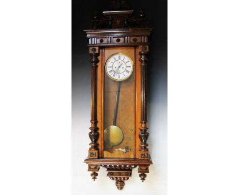 A Victorian walnut twin weight Vienna regulator wall clock, with an architectural pediment above reeded half columns flanking
