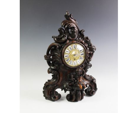 A large 19th century Black Forest mantel clock, the extensively carved rococo style case raised on scroll feet enclosing a ci