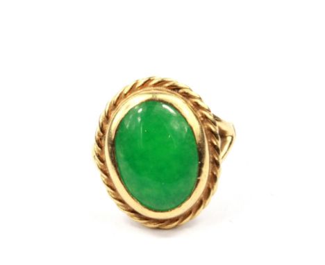 An 18 carat gold ring set with a cabochon jade stone