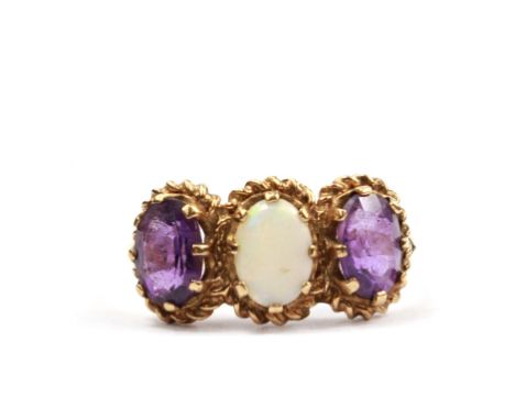 A three stone opal and amethyst ring set in 9 carat gold