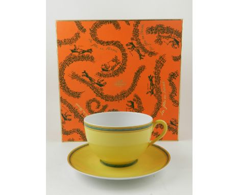 Hermes, Paris. A porcelain cup and saucer, "Toucans", decorated green edges on a yellow ground, in original box. Diameter. 12