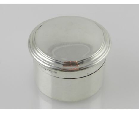 A silver and silver gilt patch box of circular form with a moulded dome top and gilded interior, hallmarked London 1919 maker