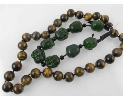A tiger eye beaded necklace, together with a spinach green jade bangle. 
