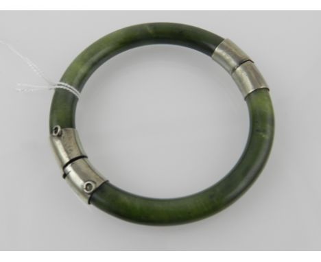 A jade bangle having silver joints. Internal diameter.6cm
