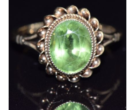 A 9ct gold ring set with an oval cut peridot, size L, 2.9g