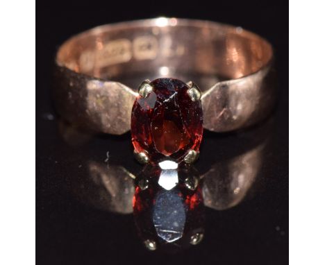 A 9ct gold ring set with an oval cut garnet, size Q, 2.4g