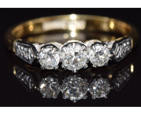 An 18ct gold ring set with three diamonds in a platinum setting,&nbsp; with two further diamonds to the shoulders, size L, 3g