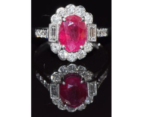 An 18ct white gold ring set with an oval cut ruby of approximately 2ct, round cut and baguette cut diamonds, size M/N, 4.7g