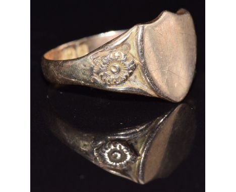 A 9ct gold shield shaped signet ring with embossed flower decoration to the shoulders, Birmingham 1917, size U, 4.7g