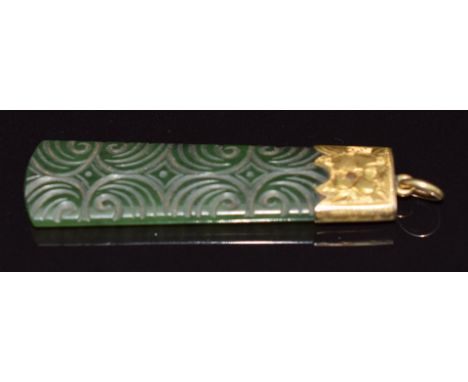 A carved nephrite jade pendant mounted in a 9ct gold pendant with engraved decoration