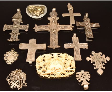 A collection of white metal crosses, a carved ivory brooch depicting chicks and mother in a nest, a silver fob and a Chinese 