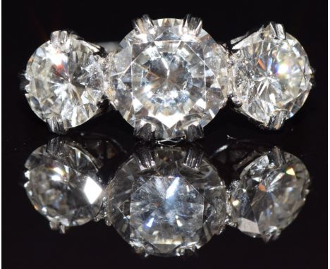 A platinum ring set with three round brilliant cut diamonds, the centre diamond approximately 2.5cts flanked by further diamo
