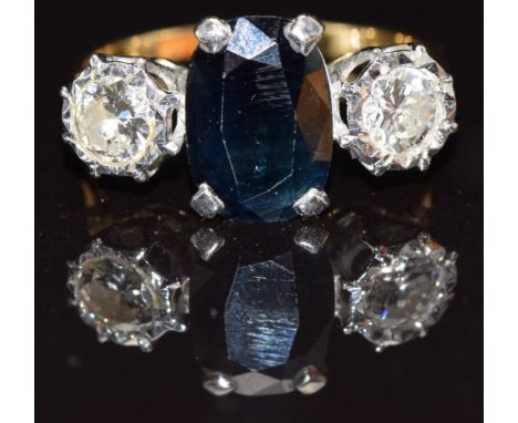 An 18ct gold ring set with an oval cut sapphire and two diamonds each approximately 0.3cts, size M, 4.1g