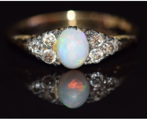 A c1920 18ct gold ring set with an opal cabochon and three diamonds to each shoulder, size L, 2.3g