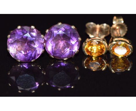A pair of 9ct gold earrings set with a yellow sapphire to each and a pair of 9ct gold earrings set with an amethyst to each, 