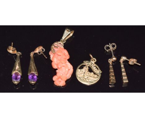 A 9ct gold pendant set with carved coral, two pairs of 9ct gold earrings, one set with an amethyst and a 10k gold charm, 9.1g