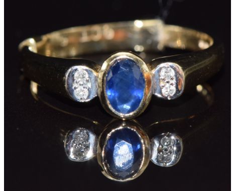 A 9ct gold ring set with an oval cut sapphire and diamonds, size N, 2.9g