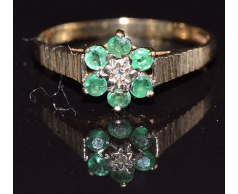 A 9ct gold ring set with a diamond and emeralds, size M, 1.3g