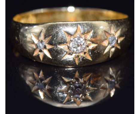 An 18ct gold ring set with three diamonds in star settings, Birmingham 1913, size M, 2.8g